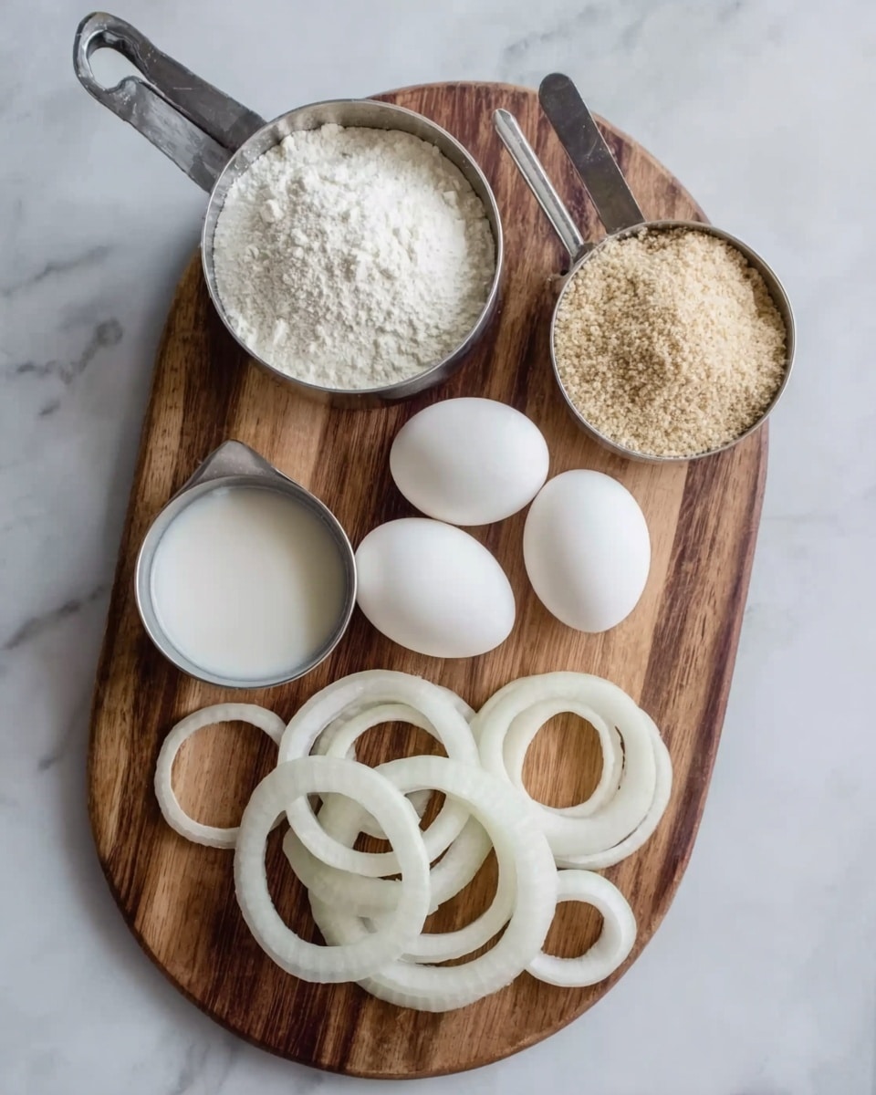 A wooden oval board is placed on a white marbled surface, holding three white eggs positioned near the center. There are two metal measuring cups at the top, one filled with light brown breadcrumbs on the right and the other with white flour on the left. To the left of the eggs, a small metal cup contains milk. At the bottom of the board, several white onion rings of different sizes are spread out in a loose pile. The photo taken with an iphone --ar 4:5 --v 7