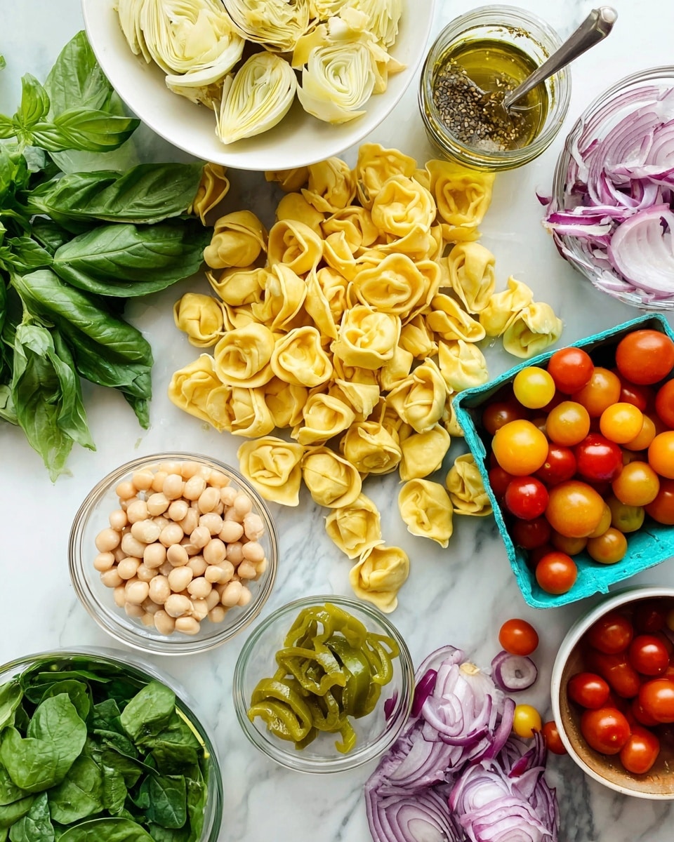 A white marbled surface holds a scattered pile of yellow tortellini pasta in the center. Near the top left, a bunch of fresh green basil leaves rests beside a white bowl filled with sliced pale yellow artichoke hearts. Just below, a small clear glass bowl contains several light green pepperoncini peppers. Adjacent to these, there is a white bowl filled with fresh green spinach leaves at the bottom left. Near the center, a clear bowl holds light beige beans, and just above this to the right there is a small jar of green herb oil with a spoon inside. On the right side, an open teal container is filled with red, orange, and yellow cherry tomatoes, with more tomatoes scattered around it. At the bottom right, a white bowl contains thinly sliced purple-red onions. The whole layout is bright, fresh, and colorful, with the ingredients arranged neatly but casually. photo taken with an iphone --ar 4:5 --v 7