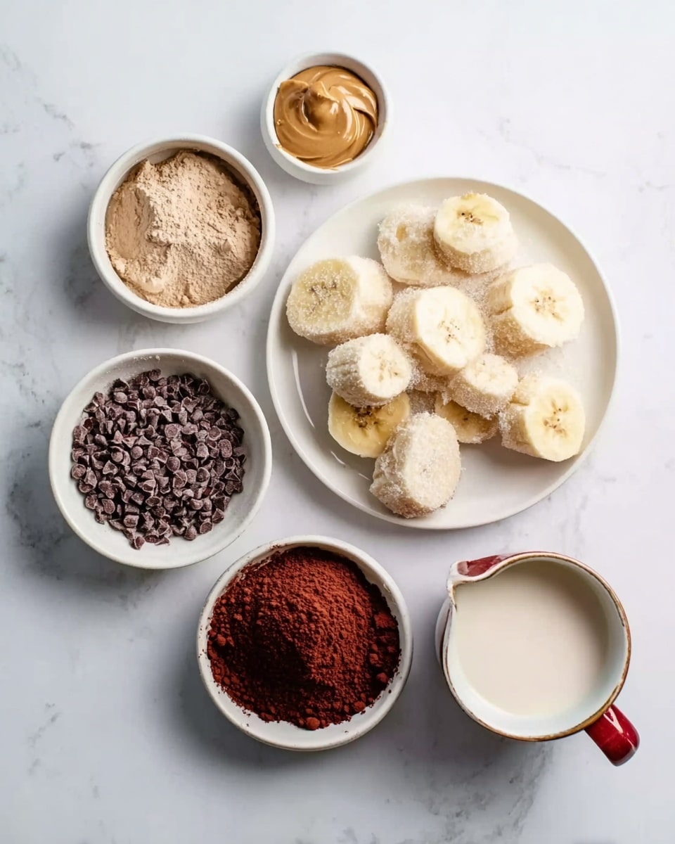 The image shows six white dishes placed on a white marbled surface, each containing a different ingredient. The top right dish is filled with large pieces of frozen banana slices, pale yellow with frosty edges. To its left, there is a small bowl of light brown sticky peanut butter. Below that, a bowl holds light brown cocoa powder with a soft, fine texture. To the right of the cocoa powder, a white cup with a red handle contains a small amount of white milk. On the far left, two bowls contain dark brown cacao nibs and deep red-brown powder, both finely textured and placed next to each other. The image is bright and clean with clear details of texture and color. Photo taken with an iphone --ar 4:5 --v 7