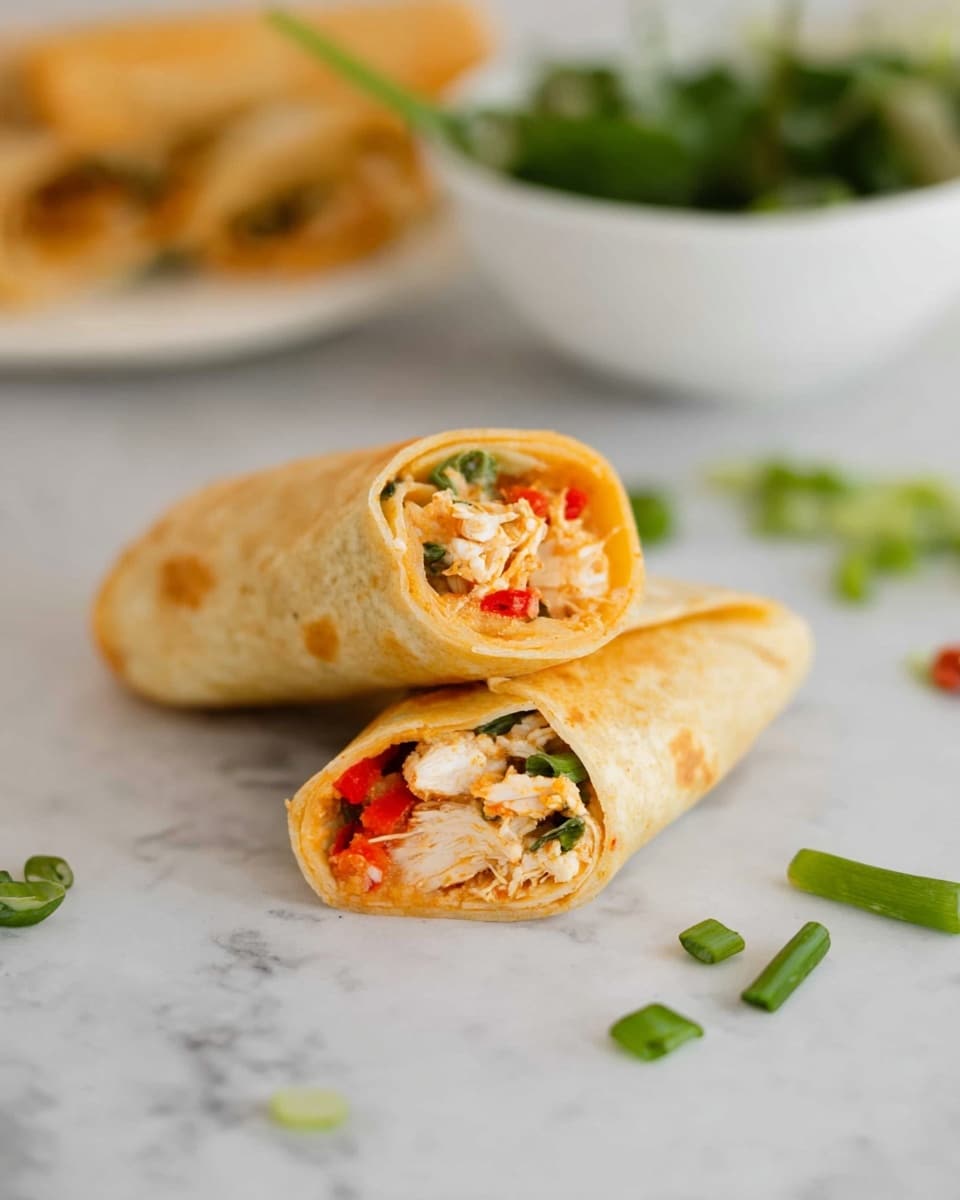 The image shows a close-up of two tortilla wraps on a white marbled surface. One wrap is whole, lying flat, and the other is cut in half and placed on top of the whole wrap, revealing the inside layers. The tortilla is golden brown with a soft texture. Inside, there are visible layers of shredded white chicken mixed with small pieces of red bell pepper and some greens. In the blurred background, a white bowl contains fresh green leafy vegetables, adding a splash of color. Nearby, some chopped green onions are scattered on the surface. Photo taken with an iphone --ar 4:5 --v 7