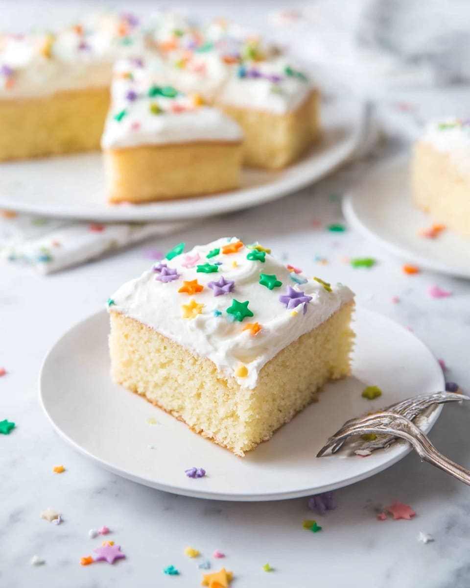 A square piece of light yellow cake with a soft, fluffy texture sits on a white plate. It has one thick, smooth layer of white frosting on top, decorated with small, colorful star-shaped sprinkles in green, orange, purple, yellow, and blue. In the background, there is a large white plate with more pieces of the cake, also topped with white frosting and sprinkles. The setting is on a white marbled surface with scattered sprinkles around the plates and a silver fork next to the plate in the front. Photo taken with an iphone --ar 4:5 --v 7