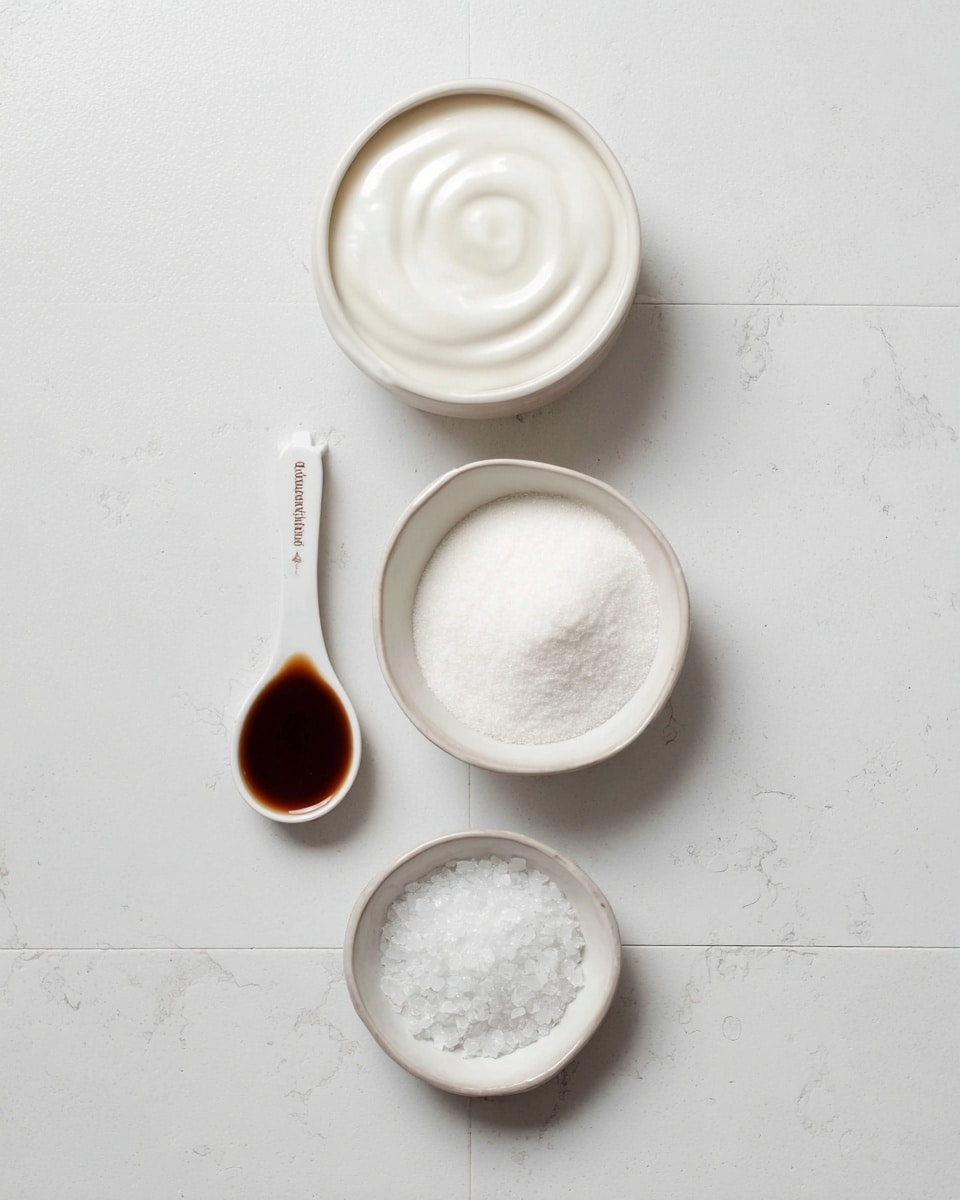 The image shows four containers on a white marbled tile surface arranged vertically. At the top is a round white bowl filled with smooth white liquid cream. Below is a white measuring spoon filled with dark brown liquid, placed horizontally. Next is a larger round white bowl filled with fine white sugar, arranged in a light swirl pattern. At the bottom is a small white bowl with coarse white salt crystals. The scene is clean and simple with soft natural light. Photo taken with an iphone --ar 4:5 --v 7