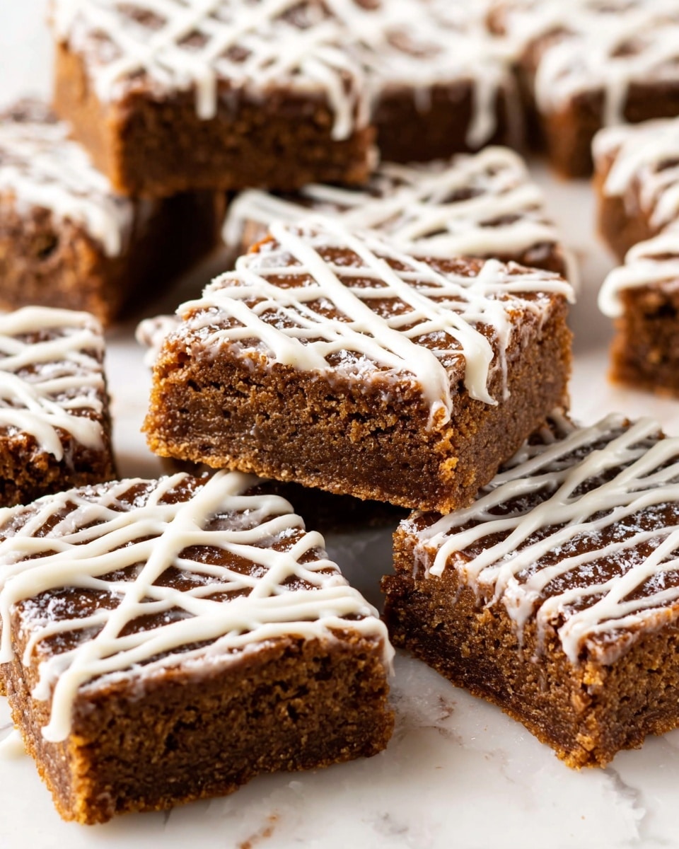 The image shows several square pieces of a dense, brown dessert with a slightly crumbly texture, arranged closely together on a white marbled surface. Each piece has a thick base layer of a rich, chewy brown mixture. On top, there is a thin but visible drizzle of glossy white icing, forming irregular lines that cross over each other, giving a decorative look. Some small pieces of the dessert are stacked, showing the same two-layer structure from the sides. The white icing contrasts sharply with the darker brown base, making the dessert look sweet and inviting. Photo taken with an iphone --ar 4:5 --v 7