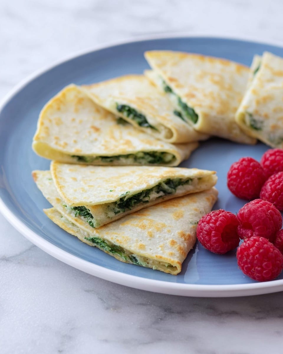 A white plate holds six folded quesadillas arranged in a circle, each showing a thin, pale yellow outer layer with a slightly rough texture. The quesadillas have a green filling visible along the edges, suggesting spinach or herbs. In the background on the plate, there is a small pile of bright red raspberries with a bumpy texture. The plate sits on a white marbled surface. Photo taken with an iphone --ar 4:5 --v 7