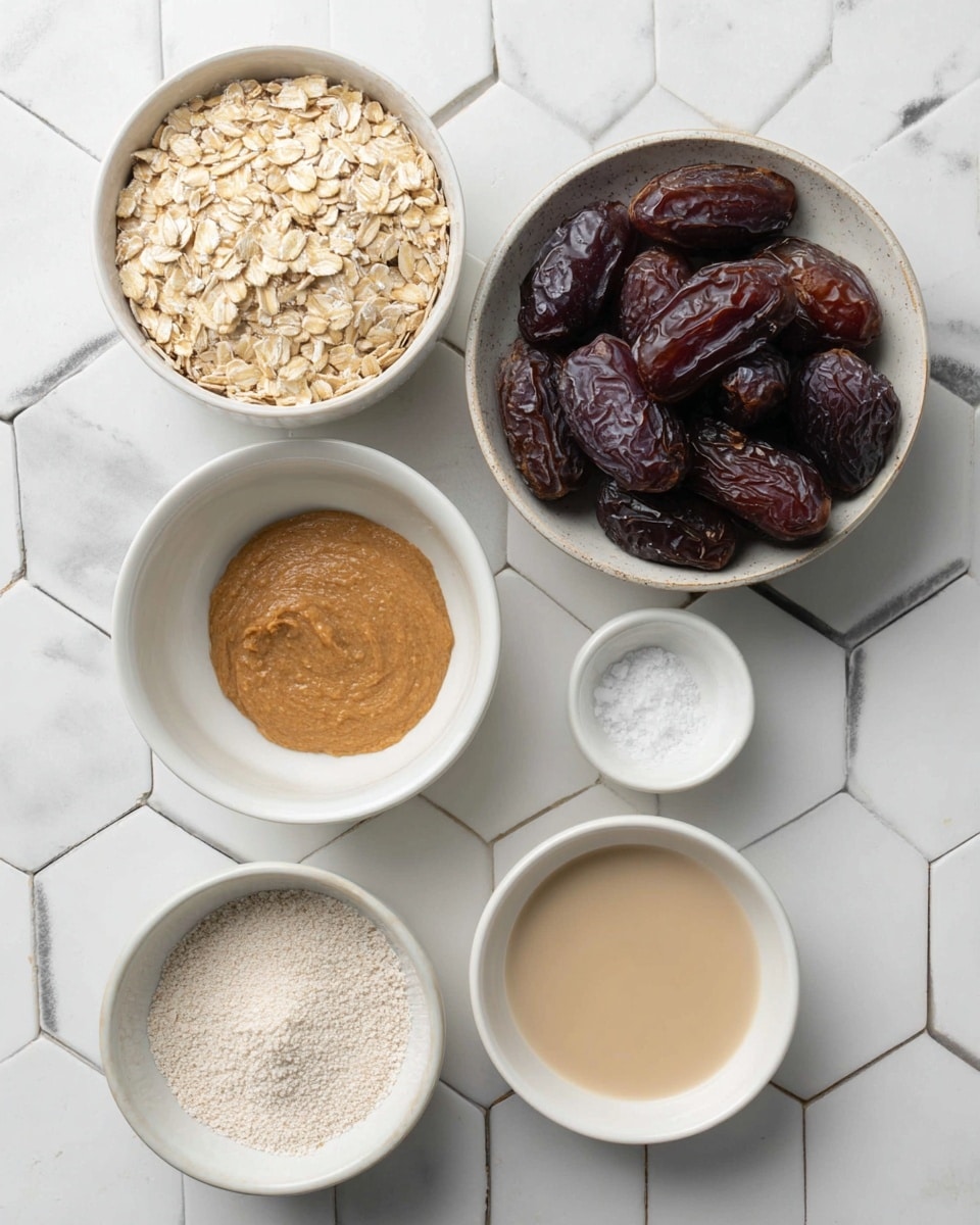 The image shows six small white bowls arranged on a white marbled surface with hexagonal tile patterns. The largest bowl at the top right contains many dark brown dates with a smooth, slightly shiny texture. To its left, a bowl filled with light beige rolled oats displaying a dry, flaky texture. Below the dates is a white bowl holding a thick, creamy light brown spread. Next to it on the left, a small pale yellow bowl contains coarse white salt. Below the oats, another small white bowl is filled with a smooth, light beige liquid. At the bottom left, a small white bowl holds fine white powder. The arrangement is neat and well spaced. Photo taken with an iphone --ar 4:5 --v 7