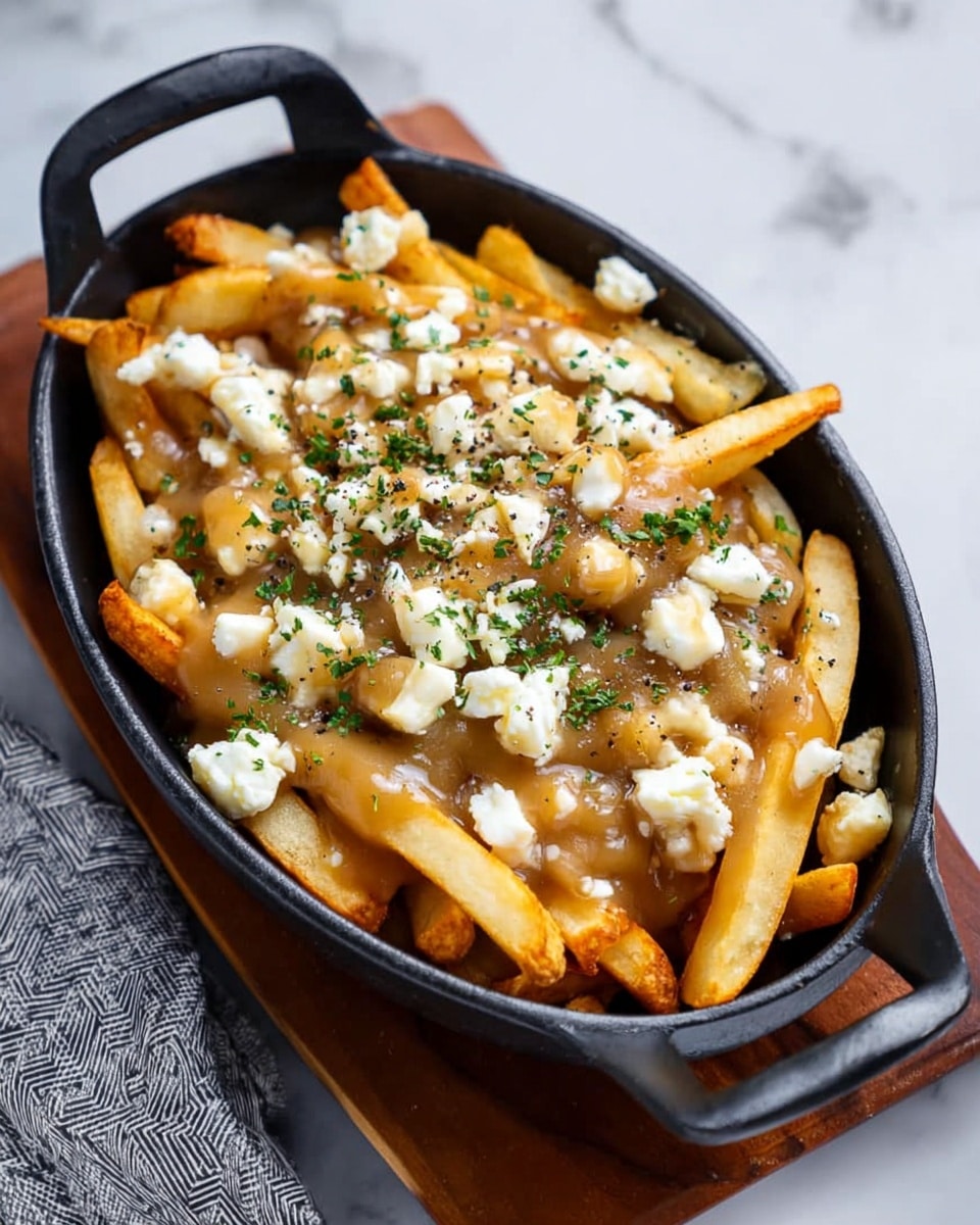 The dish shows a black oval casserole filled with crispy golden French fries as the bottom layer, covered by a thick light brown gravy that coats most of the fries. Scattered over the gravy are small white cheese chunks with a soft texture, and the whole dish is sprinkled with finely chopped fresh green herbs and a light dusting of black pepper. The casserole is on a wooden board, placed on a white marbled surface, with a gray patterned cloth partially visible on the side. photo taken with an iphone --ar 4:5 --v 7