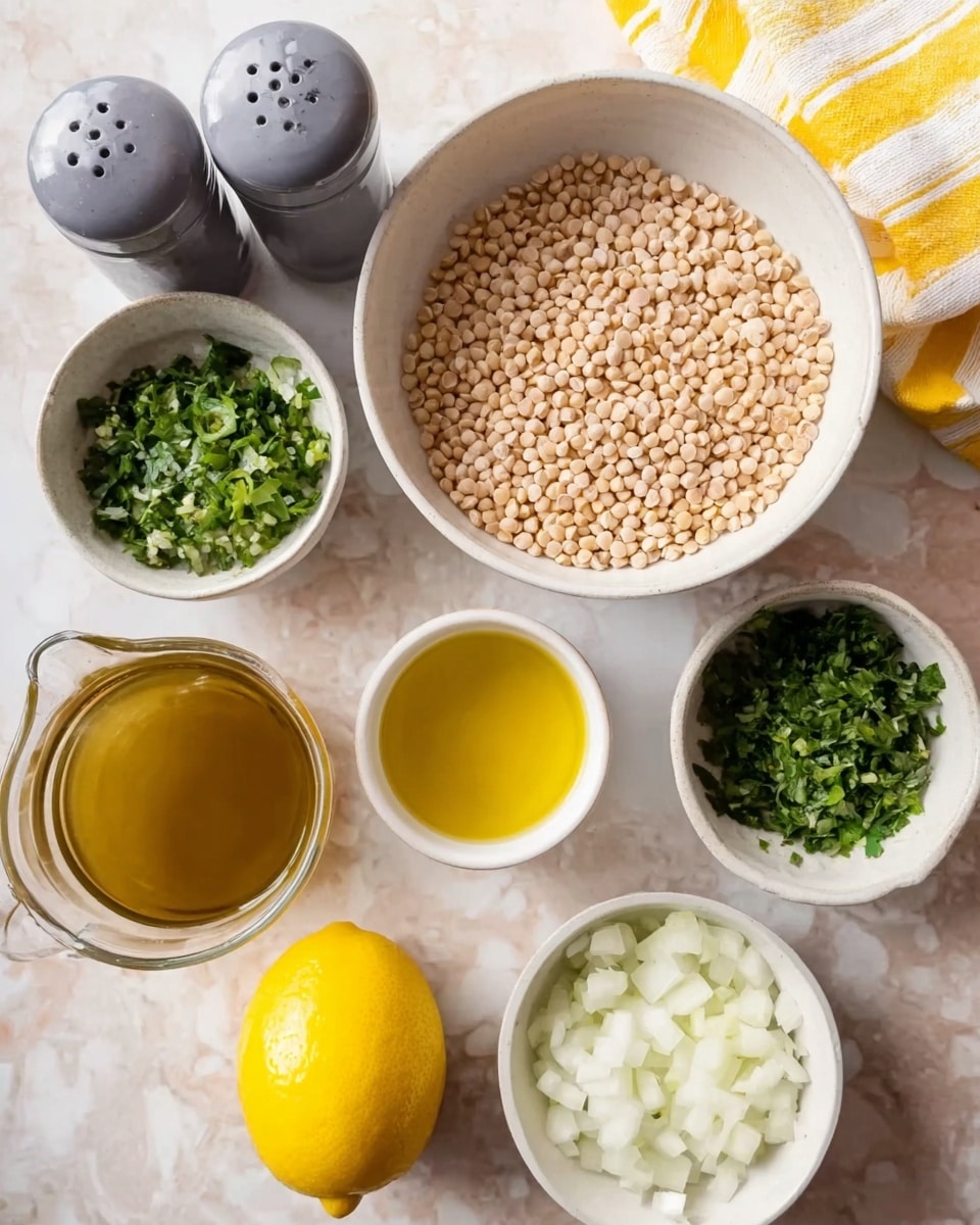 The image shows a top view of several small white bowls and a glass jug placed on a white marbled surface. In the center, a white bowl with pale tan round grains fills the scene. To the bottom right is a white bowl with chopped white onions, and to the top left is a white bowl filled with green chopped herbs. A whole yellow lemon sits between the green herbs and a small white bowl with light yellow crushed garlic. Below the garlic bowl is another small white bowl with golden-yellow olive oil. At the bottom left, there is a transparent glass jug filled with light brown broth. Two gray containers, likely salt and pepper shakers, sit on the left side near the green herbs. A yellow and white striped cloth is partially visible at the top right corner. Photo taken with an iphone --ar 4:5 --v 7
