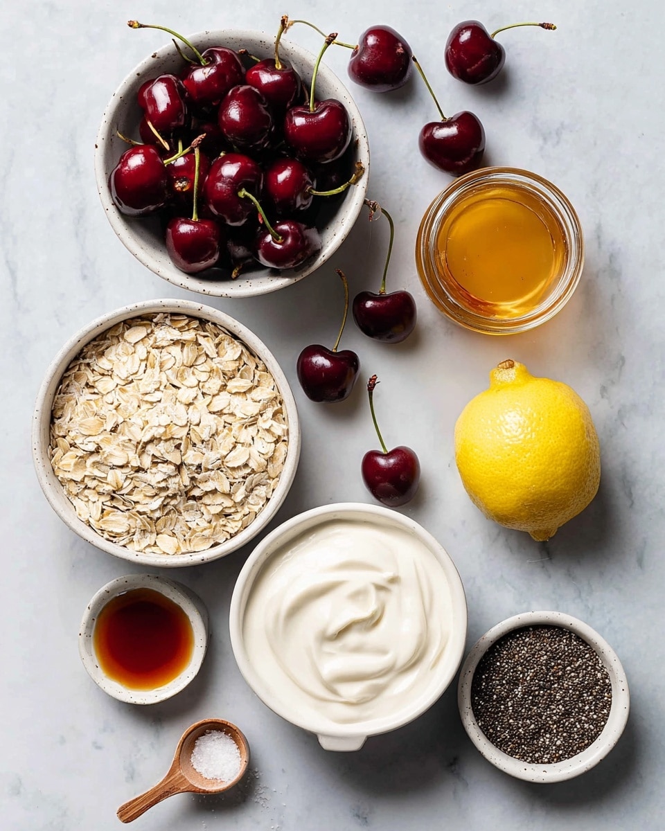 The image shows ingredients for a dish arranged neatly on a white marbled surface. There is a white bowl full of dark red cherries at the top left, and scattered cherries with stems around the surface. Below the cherries, there is a white bowl filled with light beige rolled oats. To the right of the oats, there is a small white cup with thick white yogurt, smooth and swirled on top. Above the yogurt, a small glass jar holds golden honey. Next to the honey jar on the right is a half lemon showing its bright yellow inside. At the bottom right, a small white bowl is filled with dark chia seeds. To the bottom left, a small white cup holds a dark amber liquid, likely vanilla or syrup, with a tiny wooden spoon holding some salt placed beside it. Photo taken with an iphone --ar 4:5 --v 7