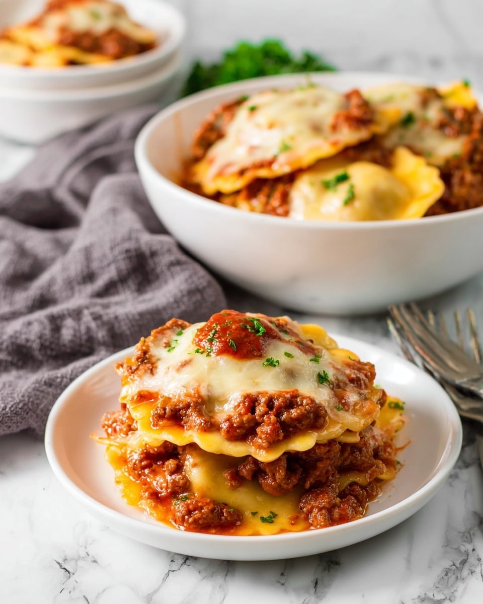 The image shows a small white round plate stacked with three large ravioli. The ravioli are pale yellow with a slightly shiny, soft texture. Between each ravioli layer, there is a thick reddish-brown meat sauce with small chunks of ground meat. The top ravioli is covered with melted white cheese that looks stretchy and lightly browned, with a small dollop of red sauce and green parsley bits sprinkled over the top. In the background, a white bowl is filled with more ravioli and sauce, placed on a white marbled surface with a gray cloth beside it, and a fork nearby. photo taken with an iphone --ar 4:5 --v 7