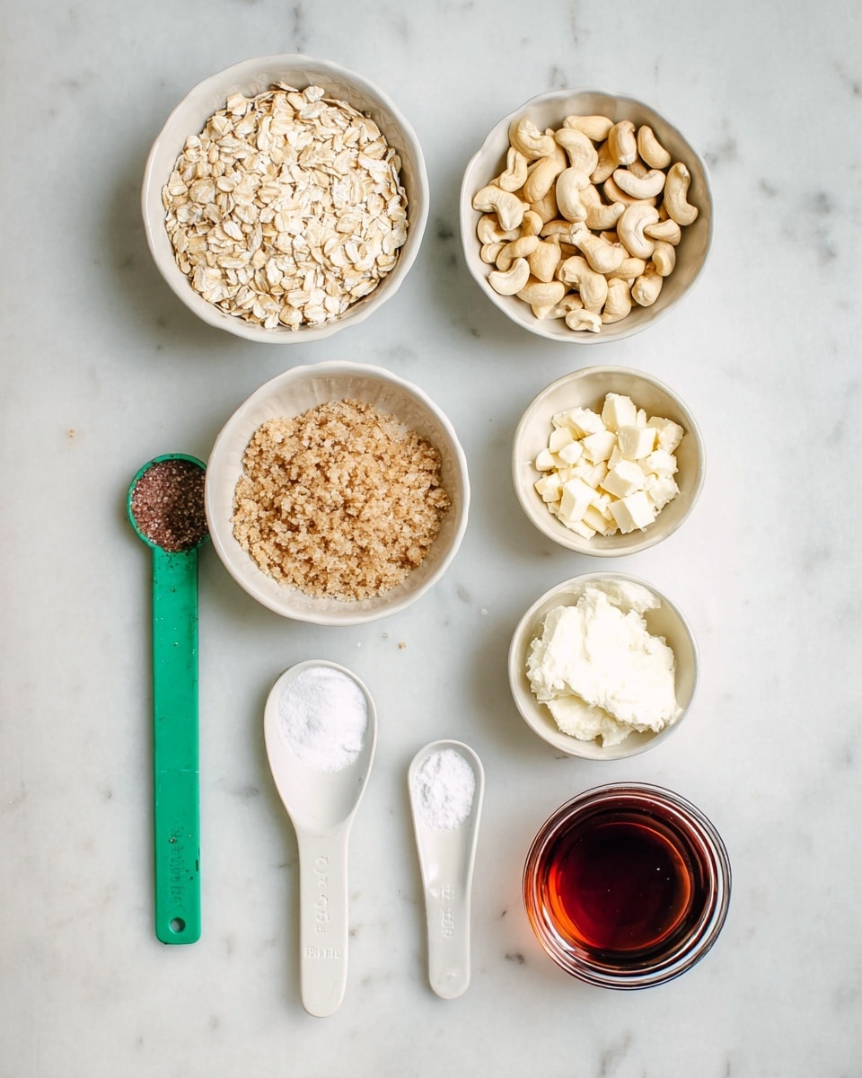 The image shows seven separate containers and measuring spoons arranged neatly on a white marbled surface, each holding different ingredients. At the top left, a white bowl is filled with light beige rolled oats with a coarse, flaky texture. To the right, a white bowl contains chopped cashew nuts that are pale cream in color and unevenly sized. Below the oats, a white bowl holds packed light brown sugar with a grainy texture and small clumps. At the bottom left, there is a green measuring spoon with a dark brown powder, and next to it, a white measuring spoon with fine white salt. To the right of the sugar, a white bowl contains a scoop of white creamy solid, likely shortening or butter. Next to it right, a small glass shot glass filled with dark amber liquid is visible, and at the bottom center, a small jar with dark reddish liquid completes the arrangement. The photo taken with an iphone --ar 4:5 --v 7