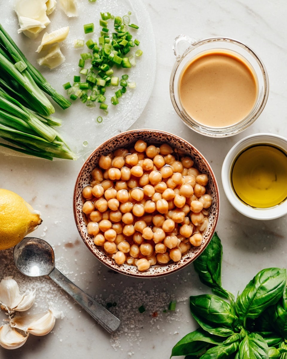 The image shows several ingredients for making a dish arranged on a white marbled surface. In the center, there is a bowl filled with light brown chickpeas soaking in water, with a speckled brown rim. Above it, a smaller bowl contains smooth, beige tahini sauce. To the right, there is a white bowl holding golden olive oil. Fresh green herbs, including basil and parsley, are scattered around the bowls. On the left side, a white plate holds chopped green onions and lemon wedges next to a garlic clove and a silver spoon with coarse salt in it. The colors in the image are earthy and fresh, with a mix of beige, white, green, and yellow tones. photo taken with an iphone --ar 4:5 --v 7