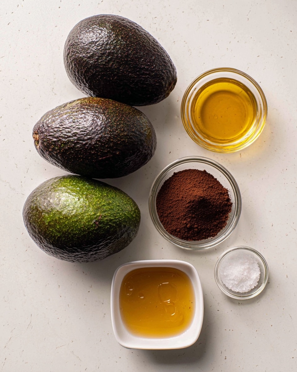 The image shows three whole, dark green to nearly black avocados with a rough texture arranged in a slight diagonal line on a white marbled surface. To the right of the avocados are five small bowls placed in a loose vertical row. Starting from the top, there is a small round white bowl containing a small amount of golden honey. Below it is a very small, clear glass bowl holding white granulated salt. Next is a square white bowl filled with fine dark brown cocoa powder, its surface slightly uneven. At the bottom, another square white bowl contains a larger amount of golden honey, smooth and shiny on top. The scene is lit softly, highlighting the textures clearly. Photo taken with an iphone --ar 4:5 --v 7