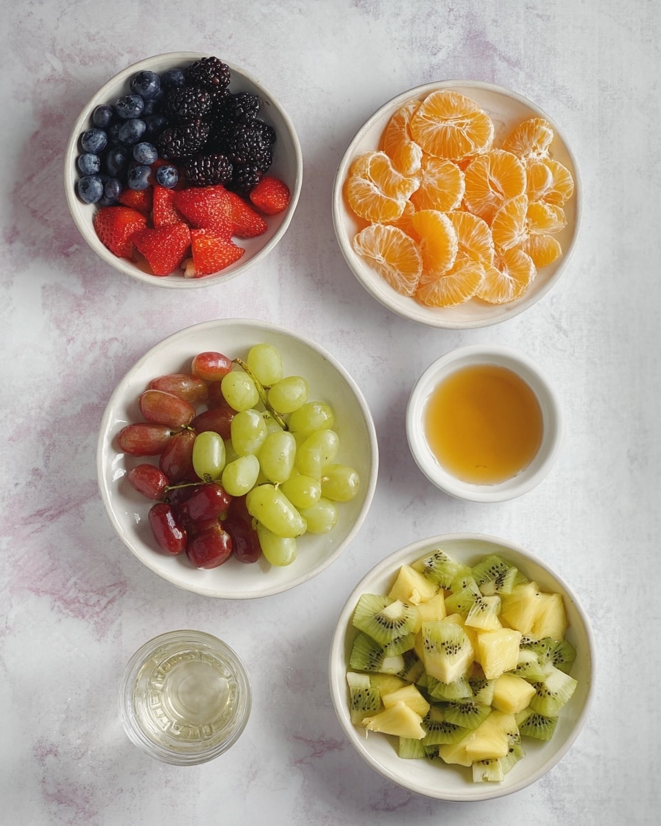 The image shows five white bowls arranged on a white marbled surface. The top left bowl contains three layers of fruits: dark blue blueberries, bright red strawberry halves, and shiny black blackberries, all mixed together. To the right, a smaller bowl is filled with bright orange peeled mandarin orange slices, arranged in a circular pattern. Below that, a medium bowl has green and red grapes, halved and mixed in one layer. Next to it on the right is a small white bowl with a golden syrupy liquid. At the bottom right, a larger bowl holds chopped green kiwis with black seeds and small chunks of yellow pineapple, mixed evenly. There is also a small glass of clear liquid near the bottom left. The photo is taken with an iphone --ar 4:5 --v 7
