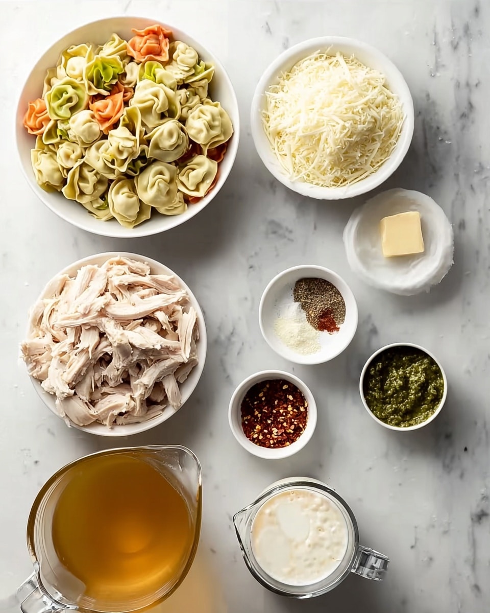 The image shows several white bowls and a measuring cup arranged on a white marbled surface. The largest bowl is filled with shredded light brown chicken, placed near the lower left. Above it and to the left is a bowl piled with colorful tortellini pasta, featuring layers of green, orange, and cream colors. To the top right of the chicken is a bowl with shredded white cheese. Small bowls containing crushed red pepper flakes, black pepper, minced garlic, and a small square of butter are scattered around. Near the bottom right is a small bowl of green pesto. A glass pitcher filled with golden broth is placed to the lower left, and a measuring cup filled with white cream is in the center. photo taken with an iphone --ar 4:5 --v 7