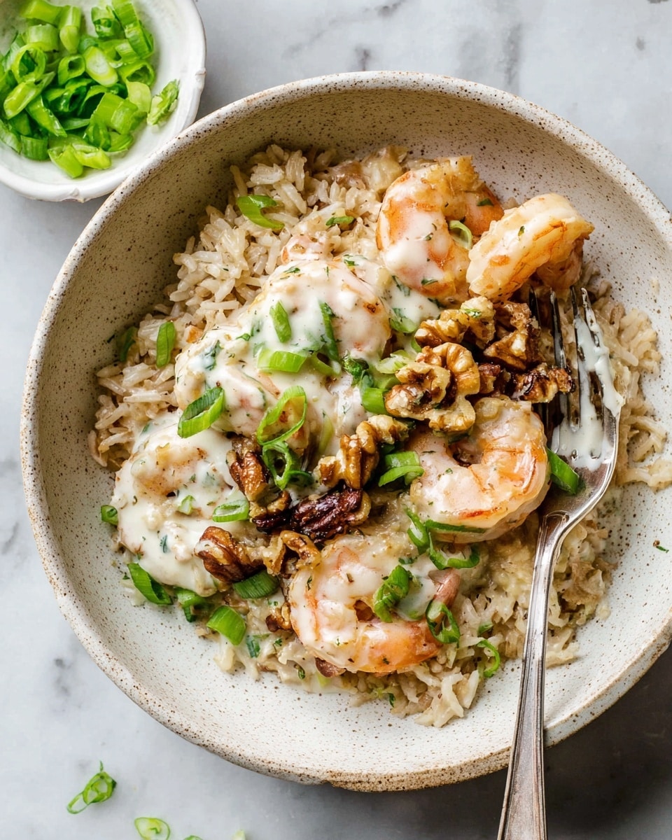 The dish shows a white speckled bowl filled with a base layer of light brown cooked rice. On top, there are several light pink cooked shrimp arranged around the center. A creamy white sauce covers the shrimp and some rice spots. Dark brown pieces of walnuts are scattered on the shrimp and sauce. Bright green chopped scallions are sprinkled over the whole dish. A silver fork rests diagonally in the bowl, touching the shrimp and walnuts. The bowl is placed on a white marbled surface with a small white bowl filled with more green scallions nearby. Photo taken with an iphone --ar 4:5 --v 7