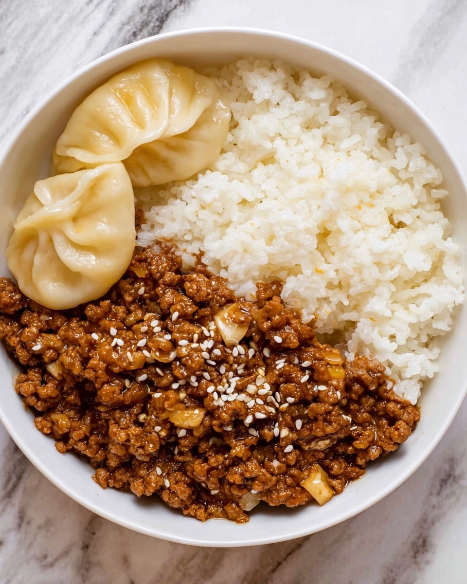 A white bowl contains three different food parts. On the right side, there is a layer of soft, white rice with visible grains. At the bottom, there is a thick layer of brown cooked minced meat mixed with small pieces of garlic or onion, topped with white sesame seeds. On the left side, there are two pale yellow dumplings with creased tops placed close to the rice. The bowl sits on a white marbled surface. Photo taken with an iphone --ar 4:5 --v 7