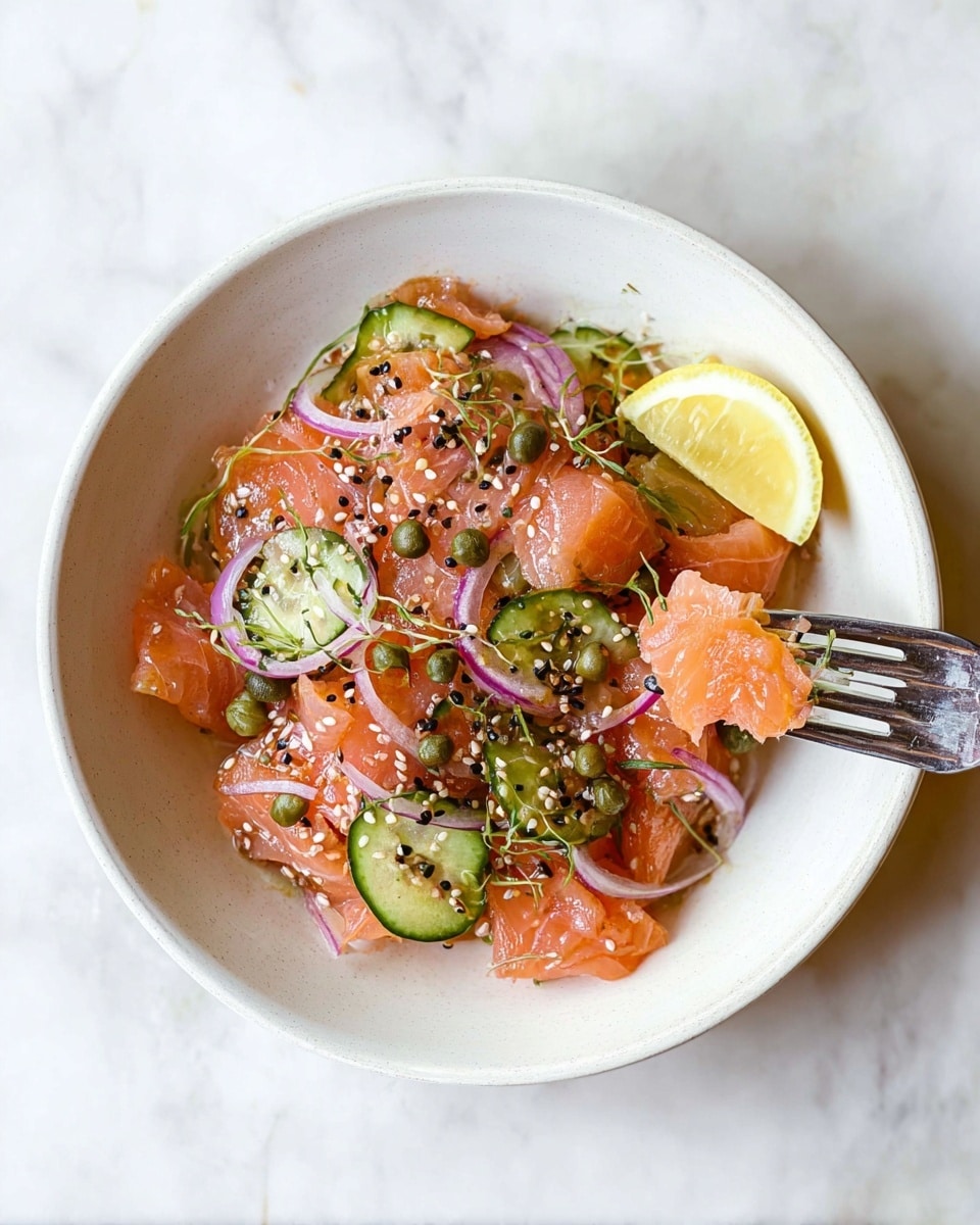 A white bowl sits on a white marbled surface, filled with several layers of thinly sliced pinkish-orange salmon pieces scattered with small green capers. Interspersed between the salmon are thin crescent slices of green cucumber and delicate rings of purple-red onion, all lightly coated in a glossy dressing. The dish is garnished with black and white sesame seeds and small green herb sprinkles. A vibrant yellow lemon wedge rests on the upper right edge of the bowl, and a silver fork holds a piece of salmon on the right side. Photo taken with an iphone --ar 4:5 --v 7