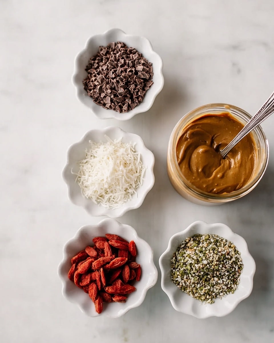 There are four small white scalloped bowls placed on a white marbled surface, each containing different ingredients: one bowl with dark brown cacao nibs, another with white shredded coconut, the third with red dried goji berries, and the last with green hemp seeds. Next to the bowls is a glass jar filled with smooth caramel-colored nut butter with a silver spoon inside. The light is soft and natural, highlighting the textures and colors of the ingredients. photo taken with an iphone --ar 4:5 --v 7