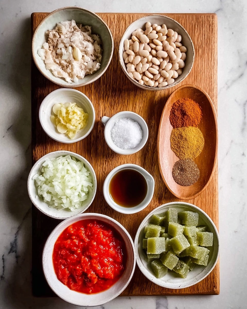 The image shows a top view of various ingredients arranged neatly on a wooden board placed on a white marbled surface. There are nine bowls and plates in total: a white bowl with bright red crushed tomatoes in the bottom right, a small white bowl with finely chopped white onions in the bottom left, a small white dish with light yellow minced garlic near the bottom center, a small white bowl with pale yellow ginger next to the garlic, a small white cup with a dark brown liquid near the top right, a wooden oval plate holding four different brownish spice powders on the top right of the board, a white bowl filled with light beige beans on the top left, a white bowl with white liquid near the center left, and a white bowl with bright green frozen cubes in the center. The ingredients show a mix of smooth, chunky, powdery, and liquid textures. photo taken with an iphone --ar 4:5 --v 7