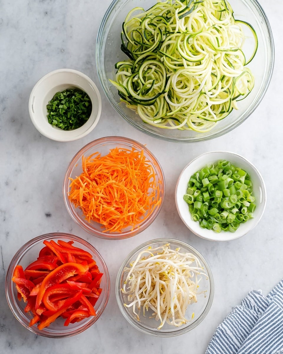 The image shows six small bowls with colorful fresh vegetables on a white marbled surface. In the top right, there is a large clear glass bowl filled with long, spiral green and white zucchini noodles. Below it to the right, a small white bowl contains finely sliced green onions. To the bottom right, a small clear glass bowl holds thin white bean sprouts. To the bottom left, a small clear glass bowl is filled with thin, long bright red bell pepper strips. In the middle left, a small clear glass bowl with bright orange shredded carrots is placed. At the top left, a small white bowl contains chopped fresh green herbs. A striped blue and white kitchen linen is partly shown in the bottom right corner. Photo taken with an iphone --ar 4:5 --v 7