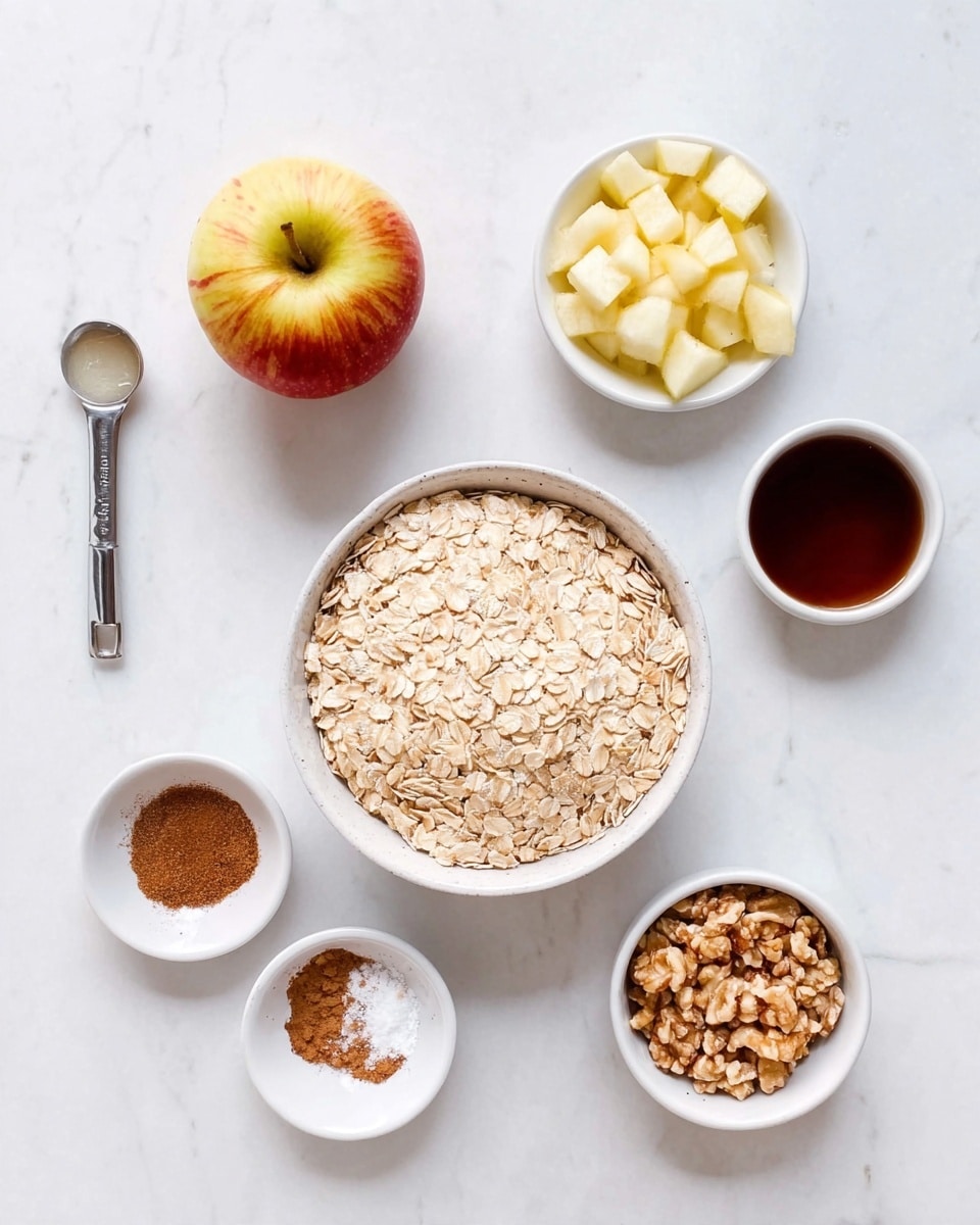 A top-down view of raw ingredients for cooking on a white marbled surface shows a large white bowl filled with light beige rolled oats at the center, a whole yellow and red apple on the left, and a small white bowl filled with small pale cream-colored diced apple pieces above the apple. To the right of the oats is a small white bowl with a thick dark brown liquid, and below it is another small white bowl with a mix of brown cinnamon powder and white powder. Below the oats is a small white pitcher with a translucent liquid inside, and to the bottom right is a small white bowl filled with crushed light brown nuts. A silver measuring spoon with a dark liquid inside lies on the left near the apple. photo taken with an iphone --ar 4:5 --v 7