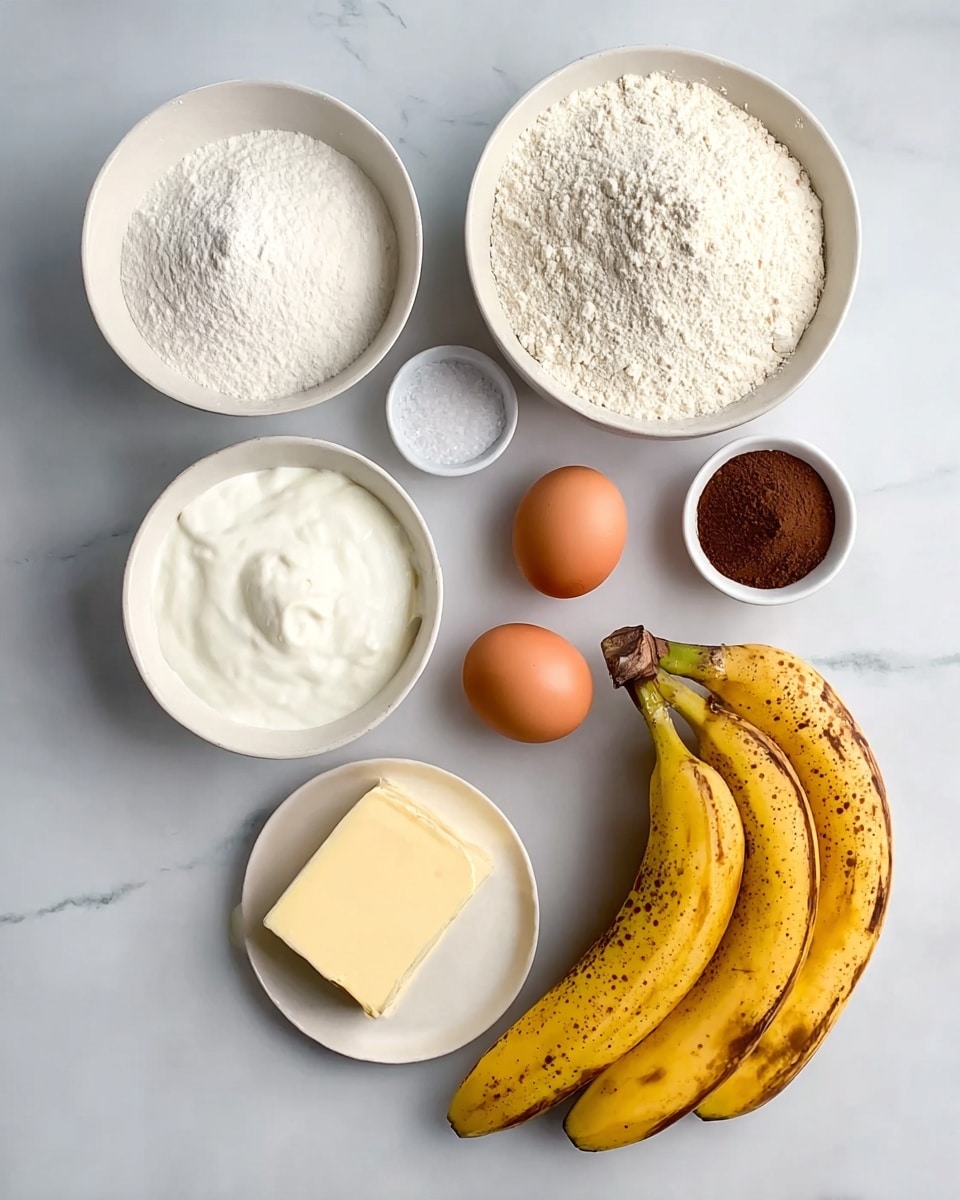 The image shows eight raw baking ingredients placed on a white marbled surface. There are two bowls with white interiors, one filled with white sugar and one with white flour sprinkled on top. A small white bowl holds fine salt, while another small white container holds dark brown powder, likely cinnamon. Alongside these, a white bowl contains thick white sour cream or yogurt. Two eggs, one brown and one white, rest together on a small white plate. Three yellow bananas with brown spots are grouped near a stick of pale yellow butter. The arrangement is neat, with each ingredient clearly visible and separated. The photo taken with an iphone --ar 4:5 --v 7