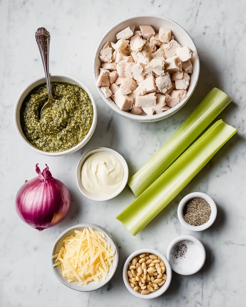 A flat lay image of ingredients on a white marbled texture, showing six white bowls and two celery stalks laid side by side. The largest bowl at the top center is filled with pale beige diced cooked chicken. Below and to the left is a medium white bowl with dark green pesto sauce and a spoon inside. To its right is a small white bowl with creamy white mayo. On the far right, a small white bowl contains a pile of golden toasted pine nuts. Below the mayo, a small bowl holds a light yellow shredded cheese. Next to it is another small bowl with coarse salt and cracked black pepper. A whole purple-red onion sits between the celery stalks and the bowls of pesto and mayo. photo taken with an iphone --ar 4:5 --v 7